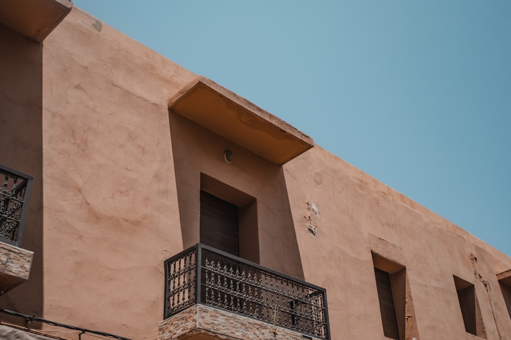 low-angle photography of brown and black concrete building under blue sky