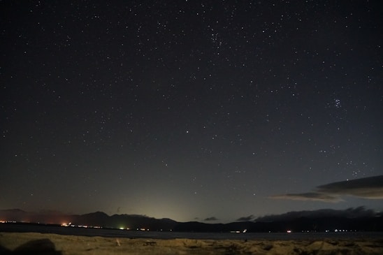 A serene night sky filled with stars above a telescope set up, ready for an astronomy session.