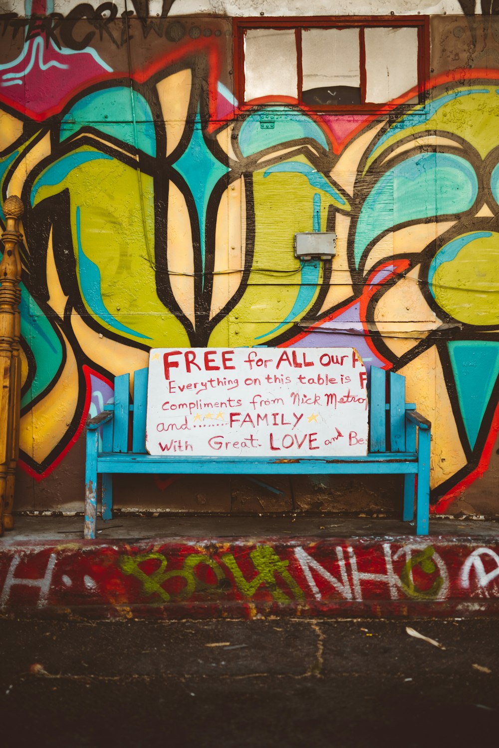 white and red text quote board on blue wooden bench during daytime