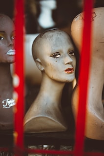 Mannequin heads mounted on tripods, lined up in a clean, modern salon space with soft lighting.