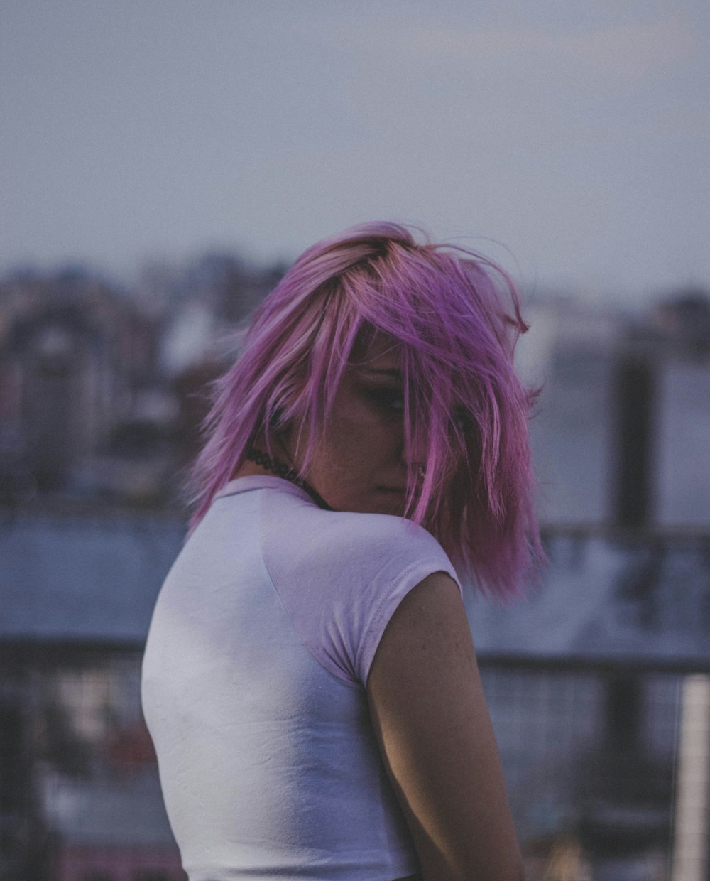 a woman with pink hair and a white shirt