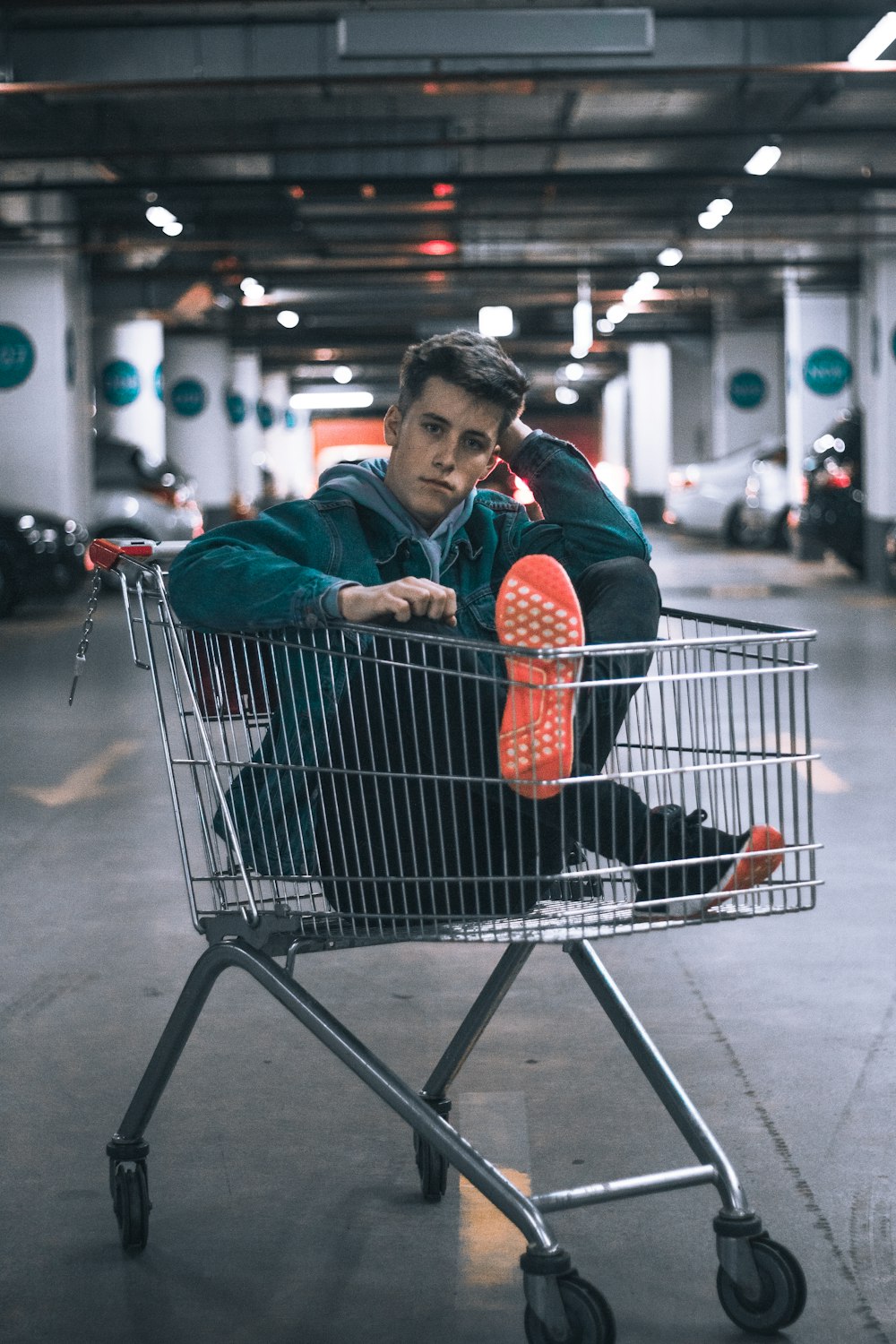 homem no carrinho de compras dentro do estacionamento do edifício