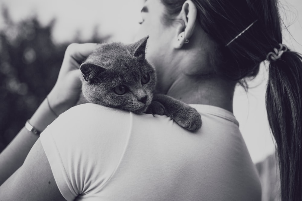 fotografia em tons de cinza da mulher que carrega o gato