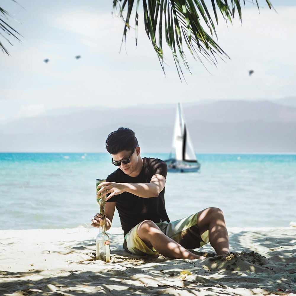 a man sitting on a beach next to the ocean