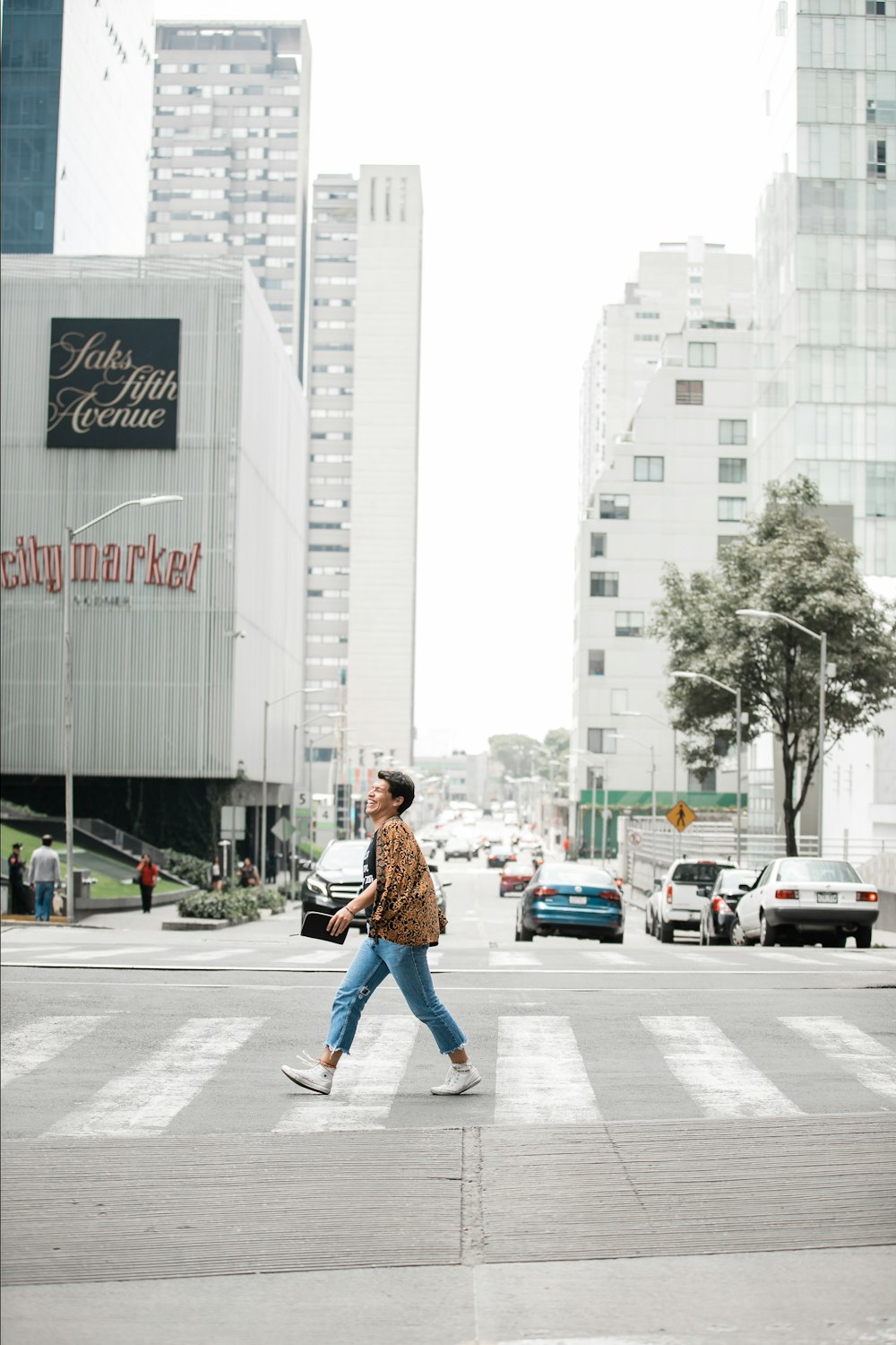 man in brown jacket walking on pedestrian lane