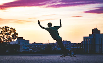 A vibrant shot of a young skateboarder cruising down an urban street with a sleek longboard at sunset.