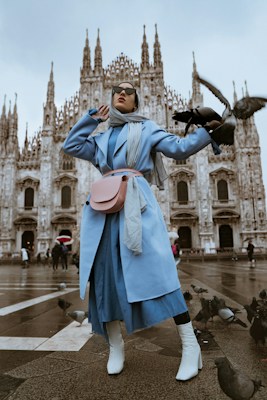 A stylish person wearing a tailored coat and sunglasses
