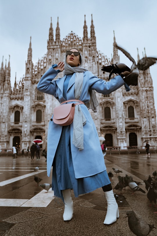 woman near pigeons in Duomo di Milano Italy