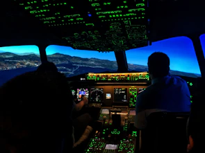 Close-up of an attentive aviation training session with students and instructors collaborating around flight simulators.