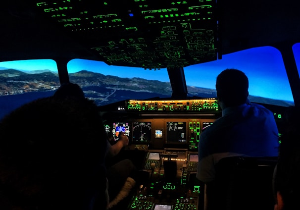 two men sitting on aircraft control panel