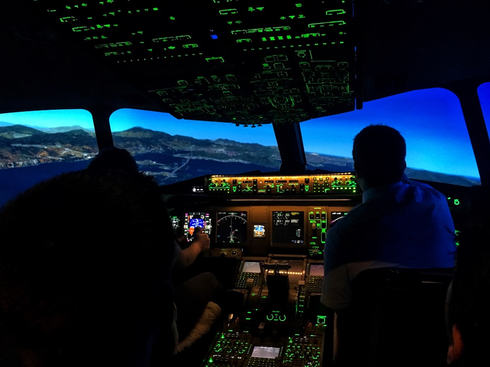 two men sitting on aircraft control panel