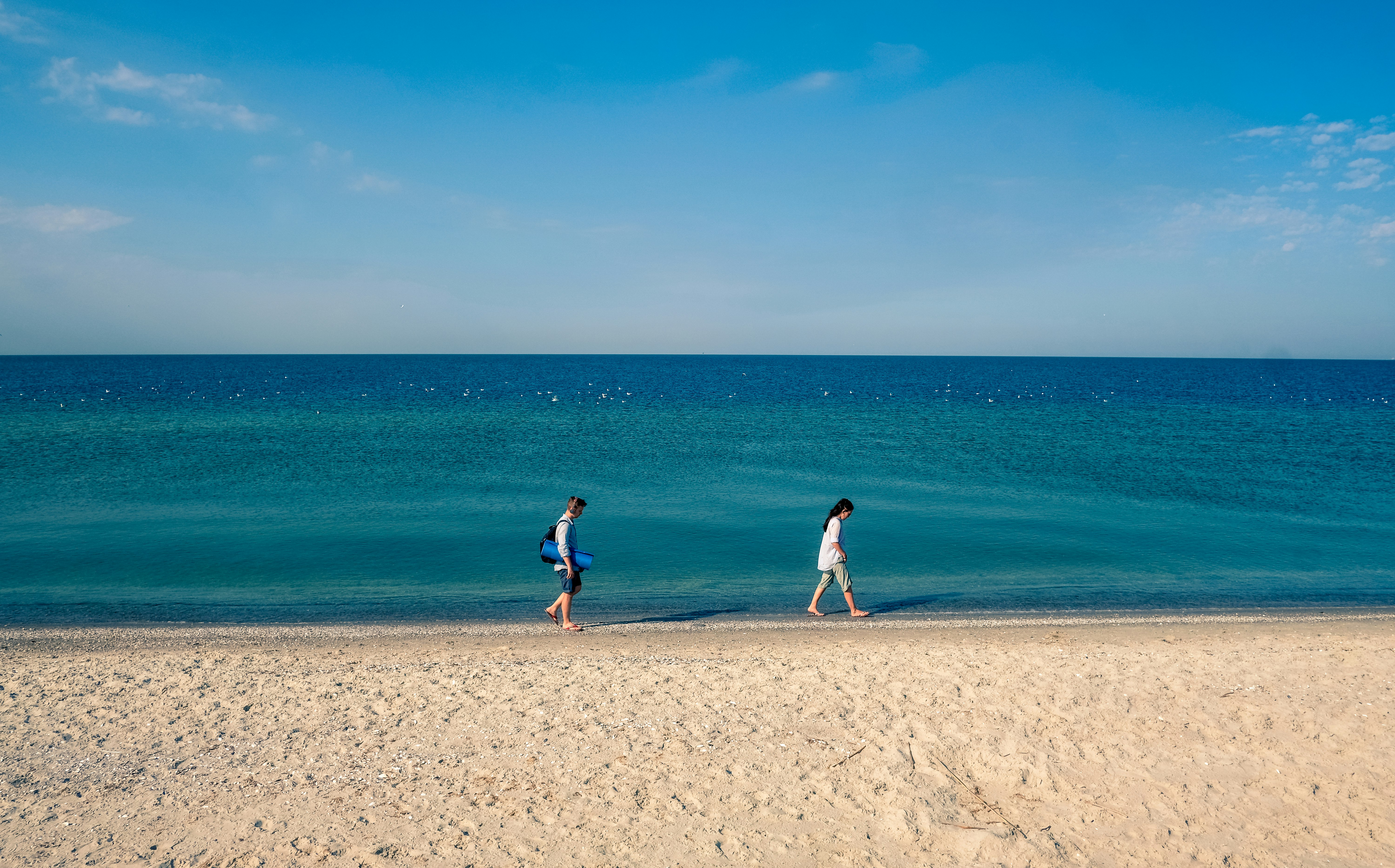 man and woman standing on beach shore