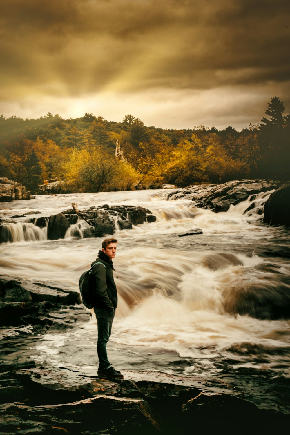 man standing beside river