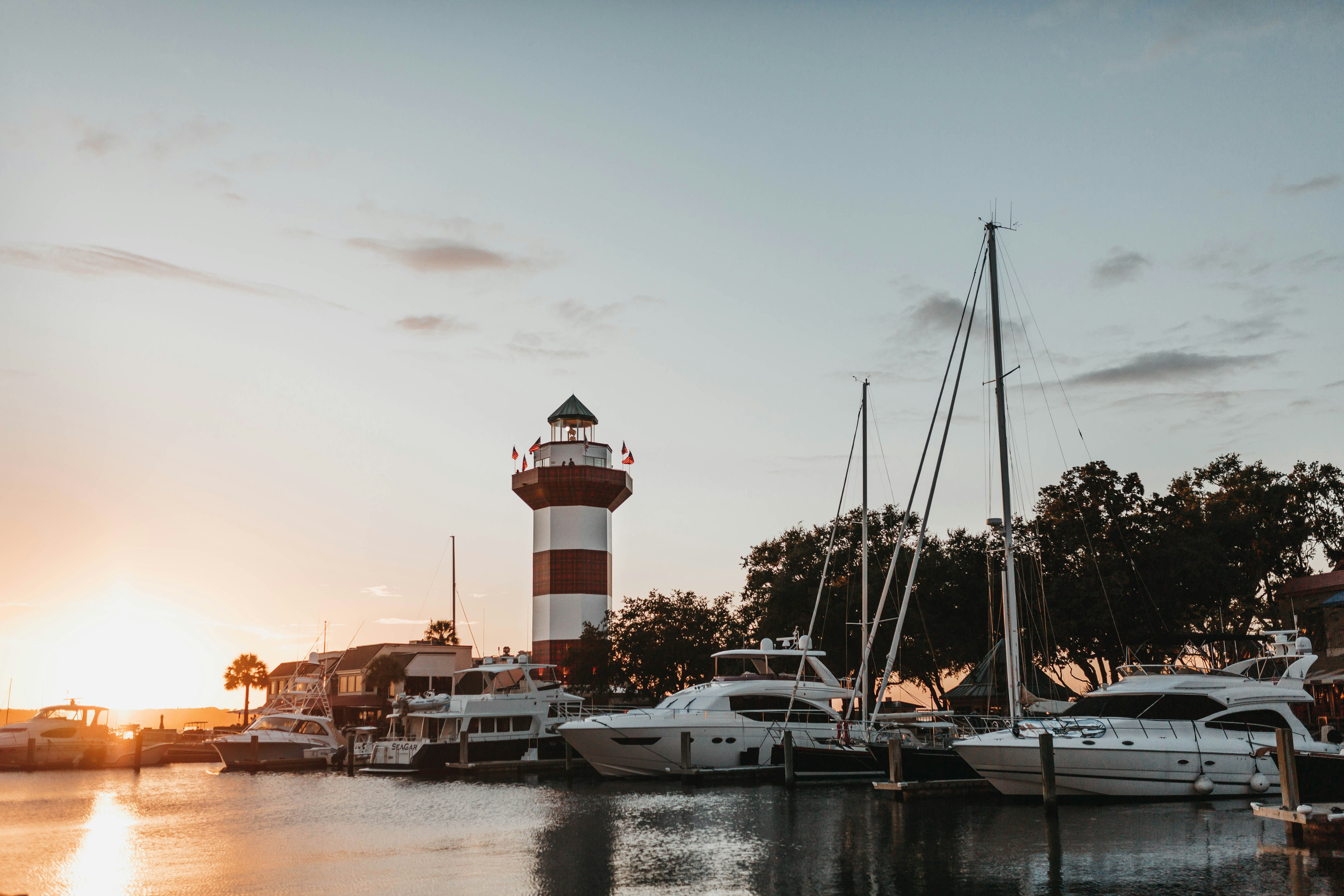 docked boats near lighthouse