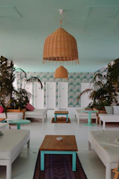 A peaceful treatment space featuring soft linens, warm gold accents, and lush tropical plants.