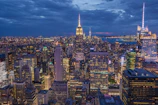 A vibrant cityscape at dusk showcasing sharp contrasts and glowing lights.