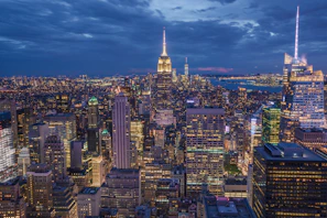 A vibrant cityscape at dusk showcasing sharp contrasts and glowing lights.
