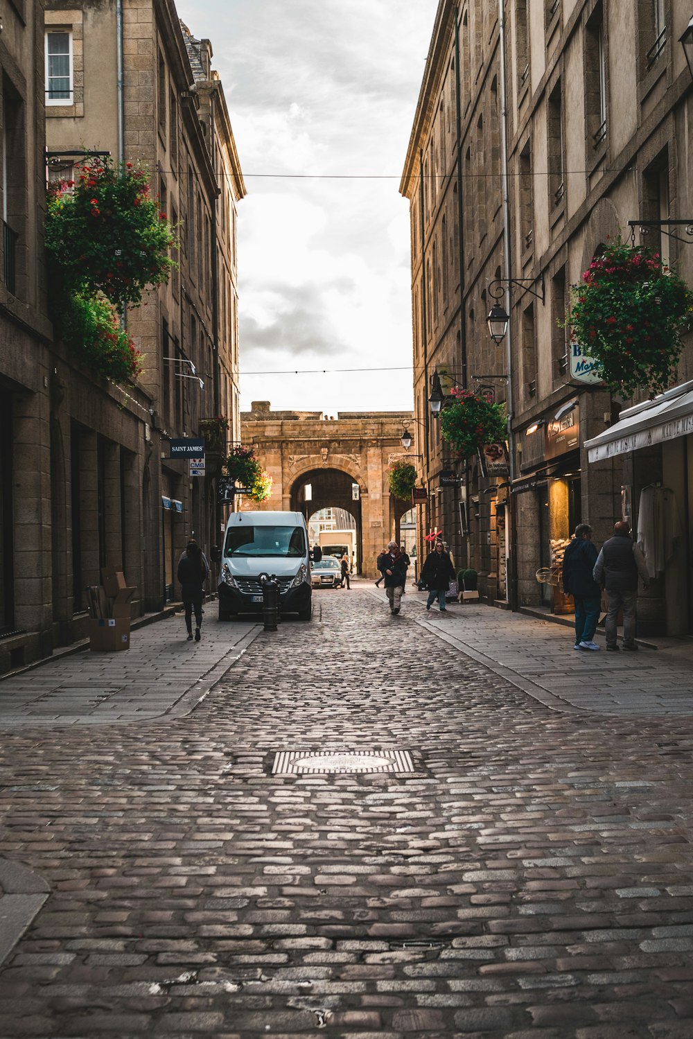 white van parked between narrow buildings during daytime