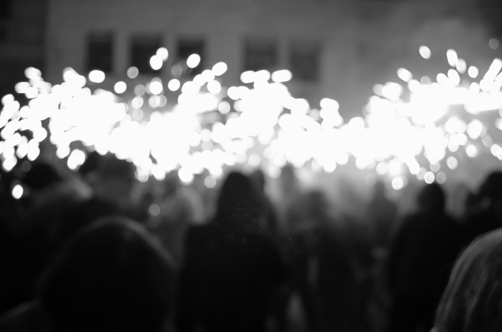 a black and white photo of people watching fireworks