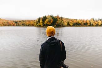 person standing facing body of water