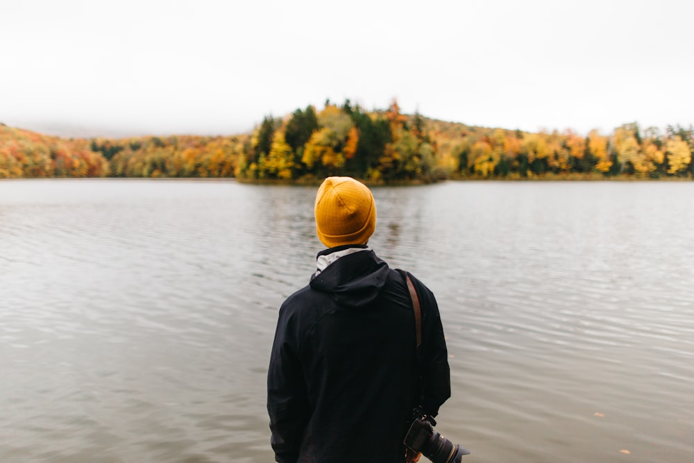 person standing facing body of water