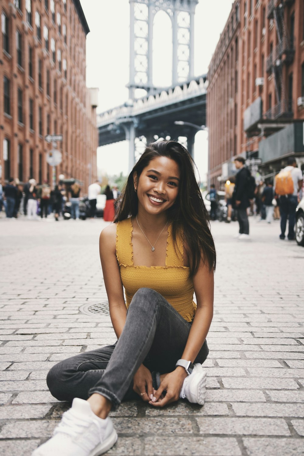 smiling woman sitting on pathway