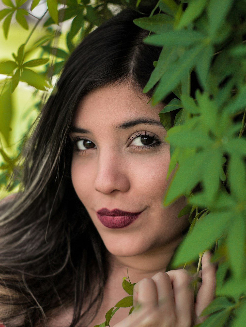 woman taking selfie next to green leaf plant