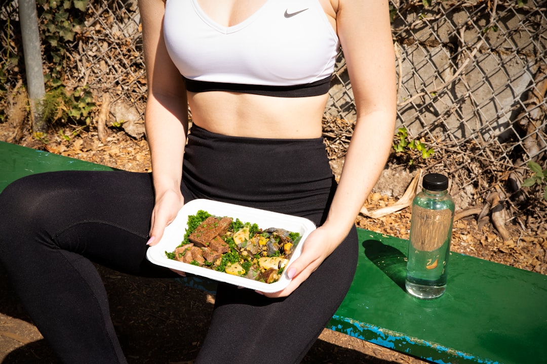 woman wearing white and black Nike sports bra, Prepared this high protein steak + veggies dish. Great after-workout fuel.