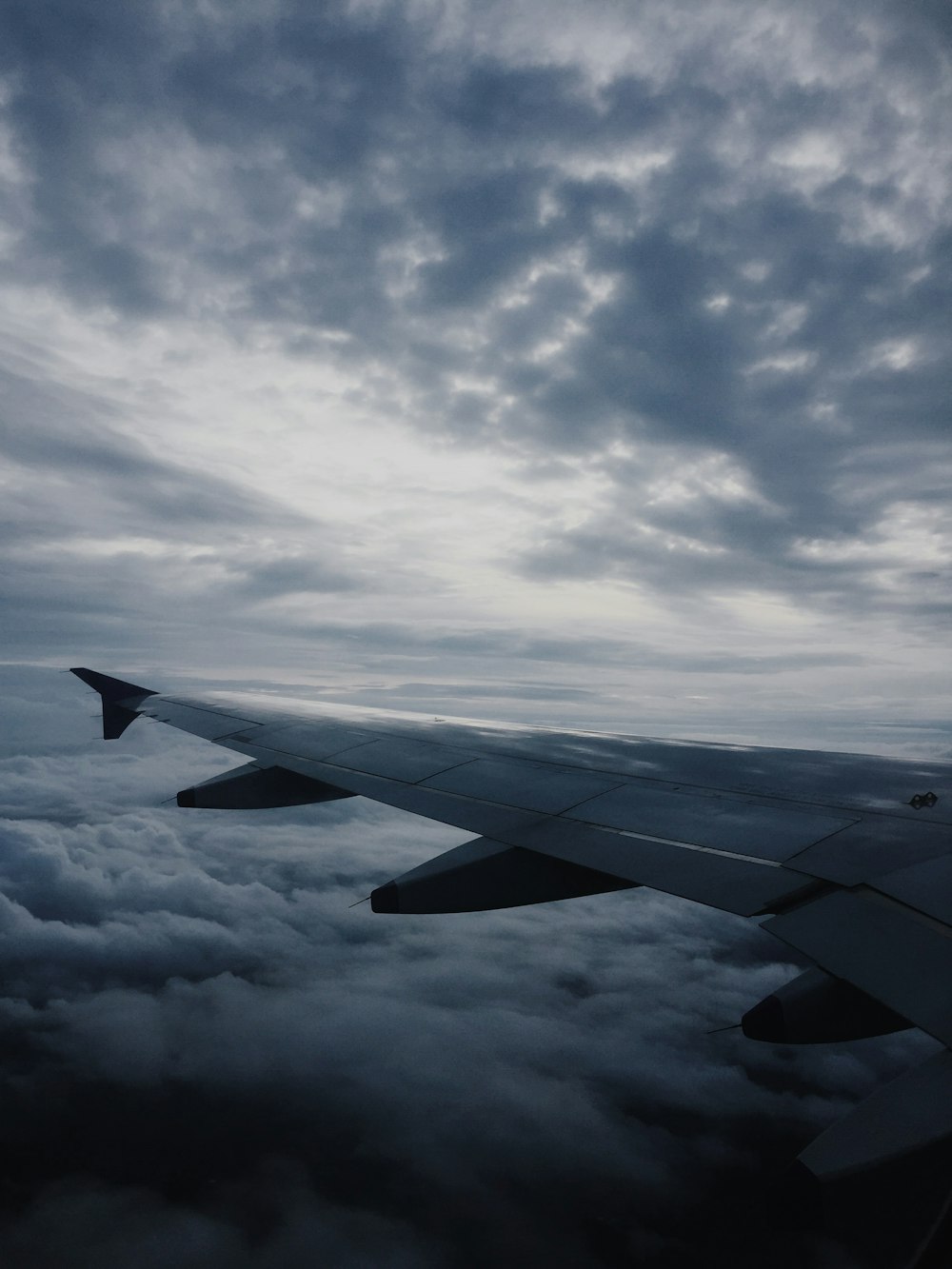 airplane wing under nimbus clounds