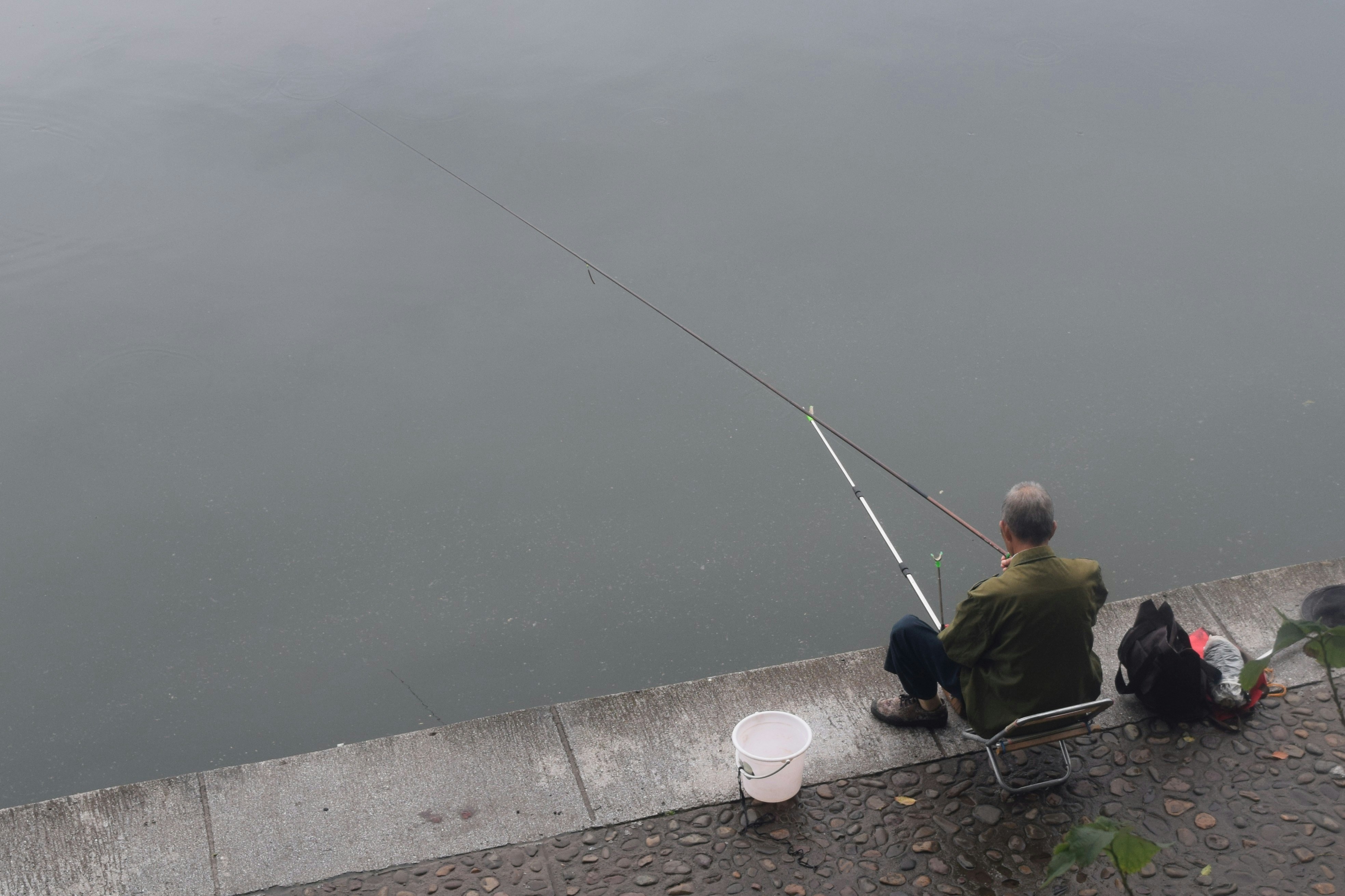 man fishing beside body of water