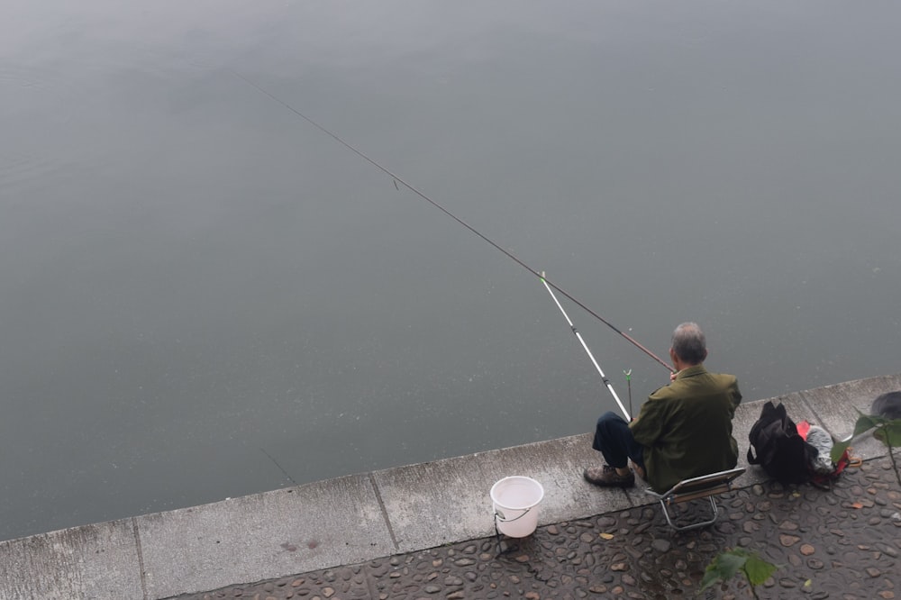 hombre pescando junto a un cuerpo de agua