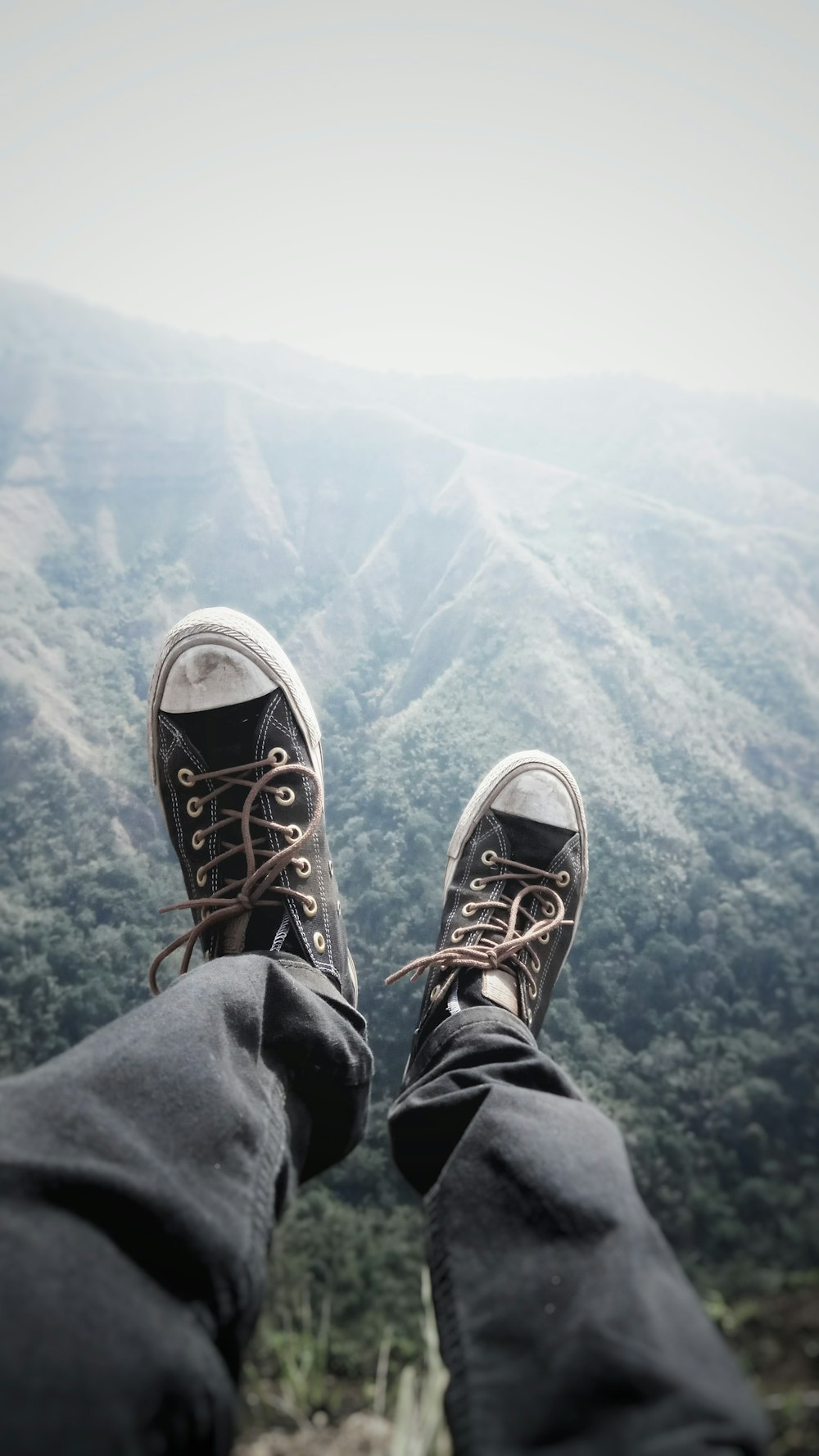 person wearing black denim jeans and black Converse All Star low-top sneakers