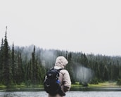 man standing near pine trees