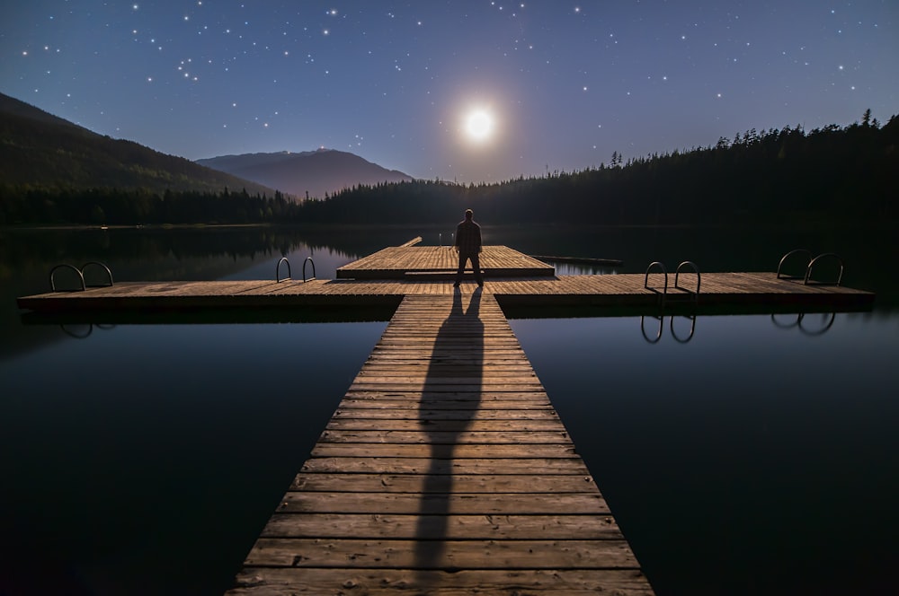 person standing on beach dock