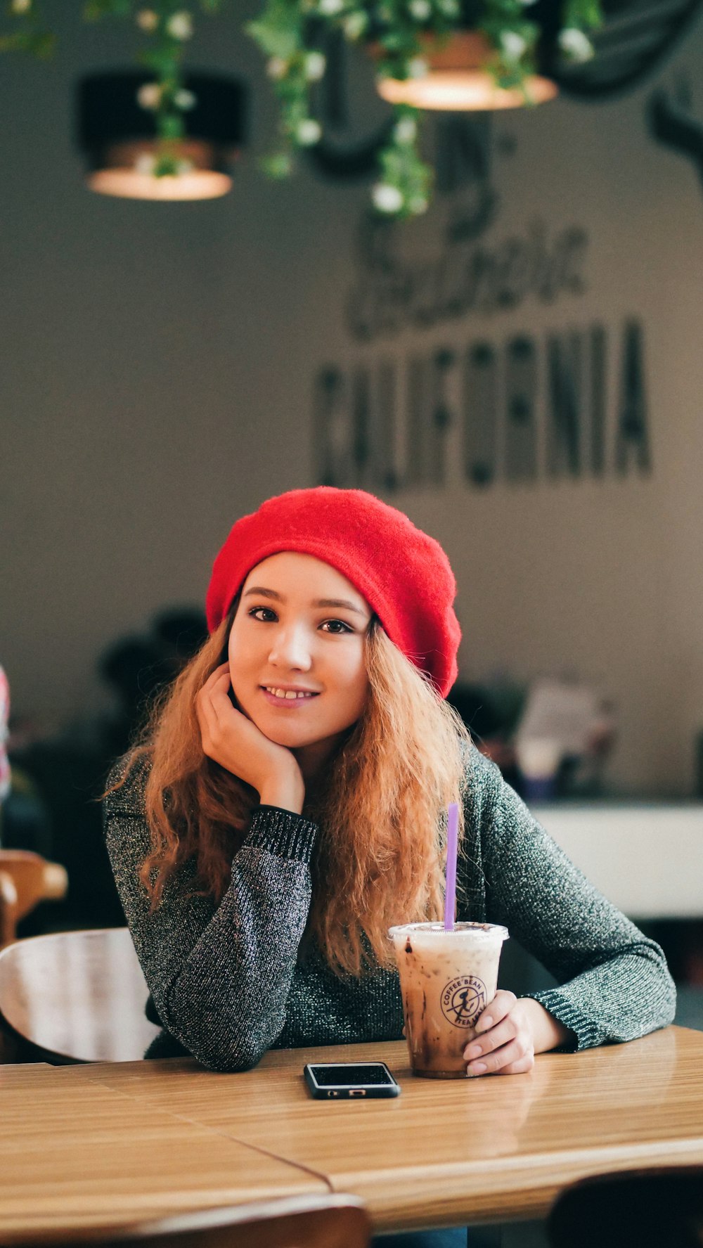 smiling woman sitting in front of table