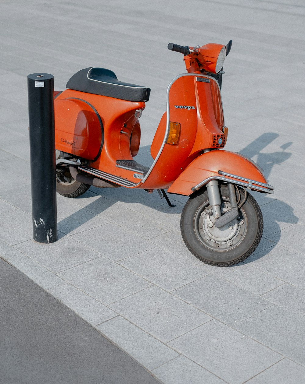 red and black motor scooter on gray pathway