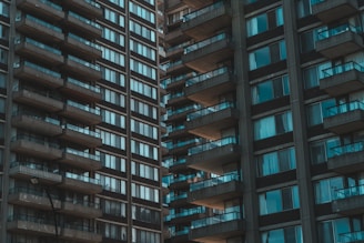 High-rise apartment buildings with numerous balconies and windows. The structures are closely positioned, creating an urban and dense architectural style.