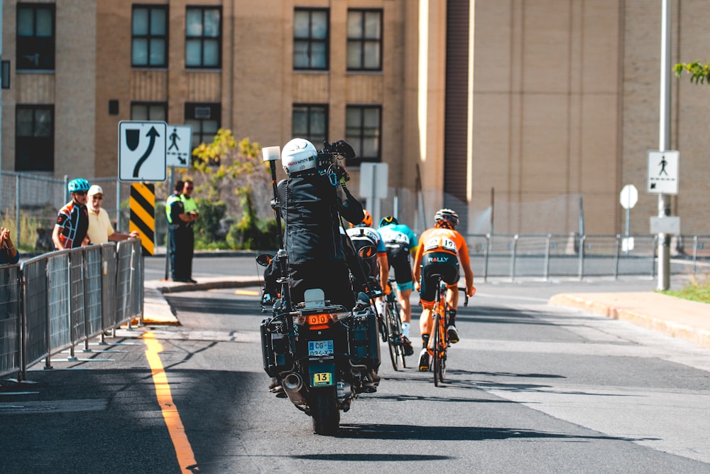 man riding motorcycle near cyclist during daytime