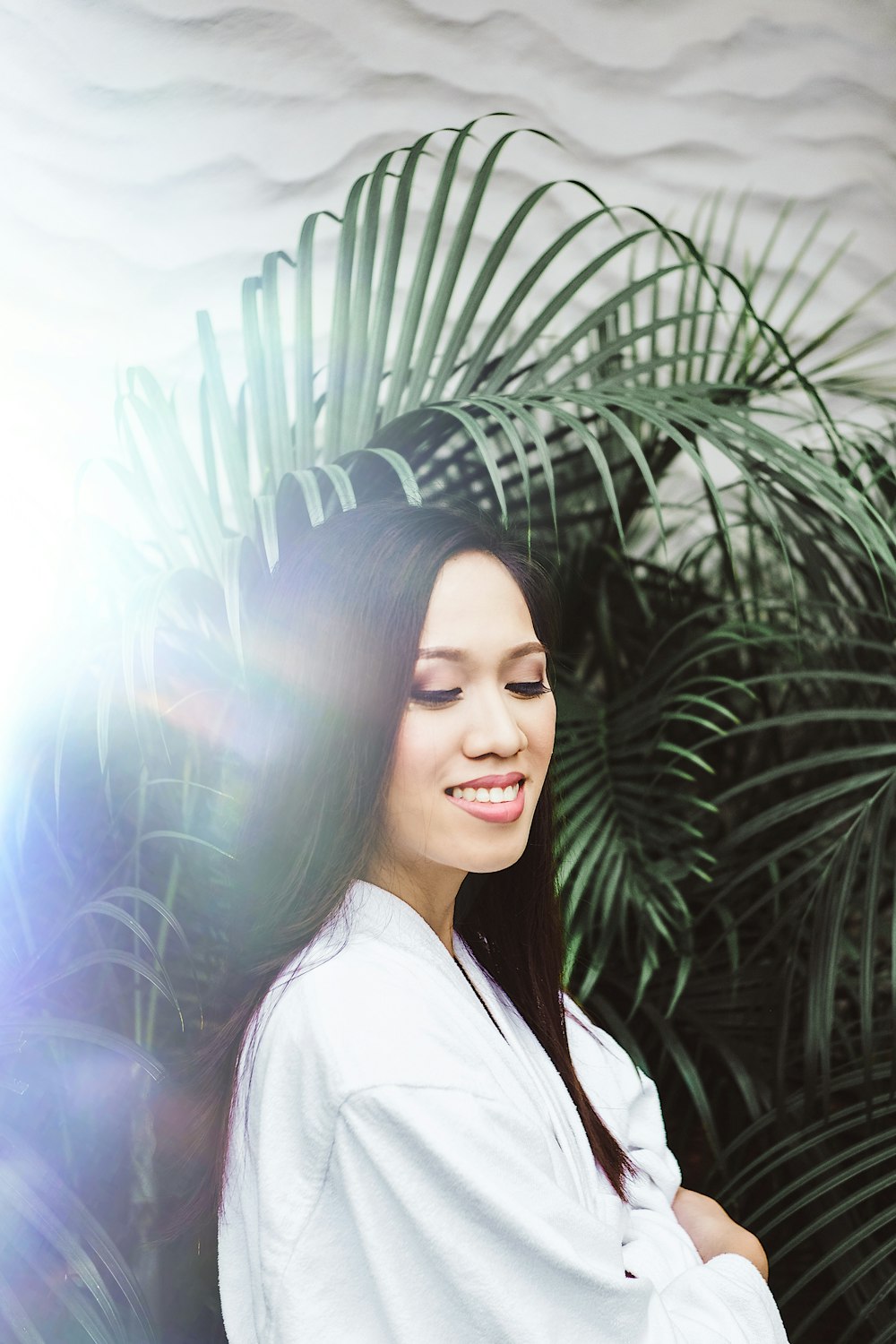 woman standing under fern plant