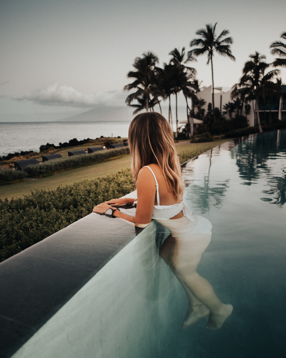 woman wearing white bikini in pool during daytime