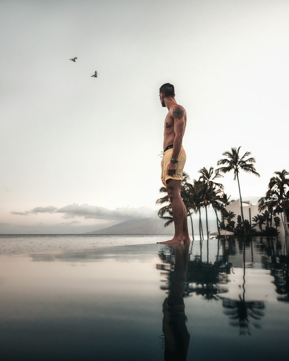 person standing on body of water reflecting on water