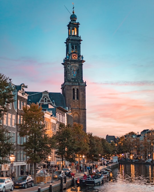 brown clock tower under golden sky in Westerkerk Netherlands