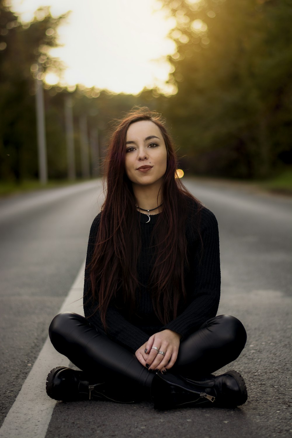 woman sitting in middle of road with cross legs