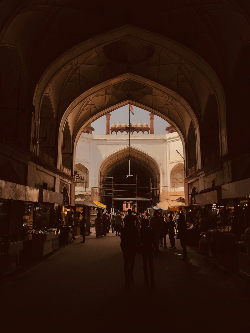 crowd walking under arch shed