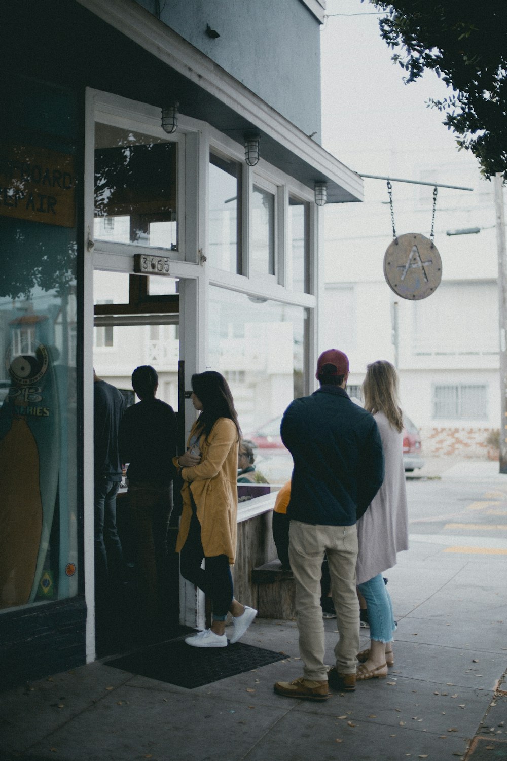 three people standing near glass door