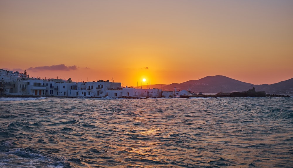 building near calm sea during sunset