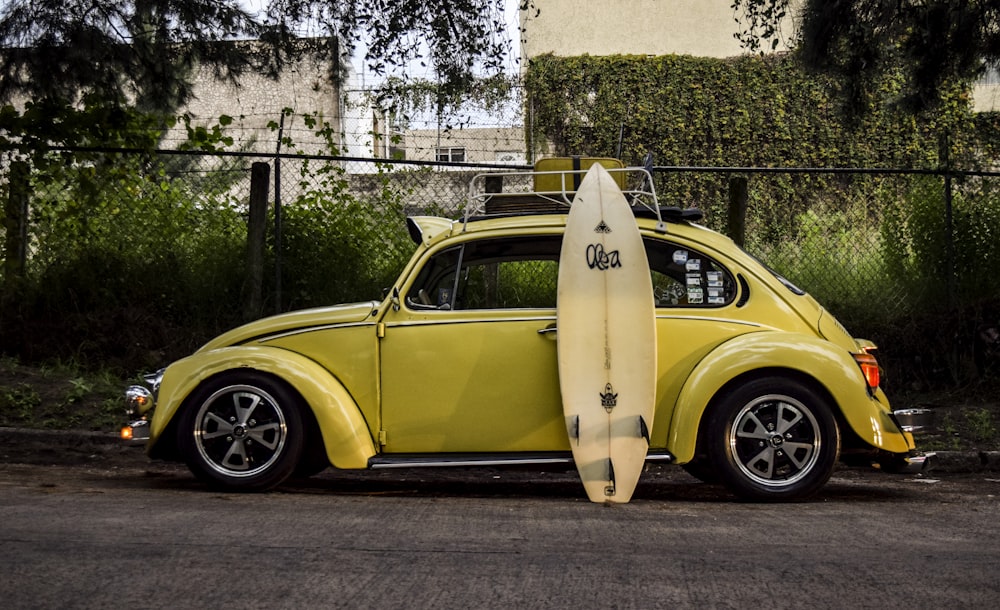 surfboard leaning on yellow car