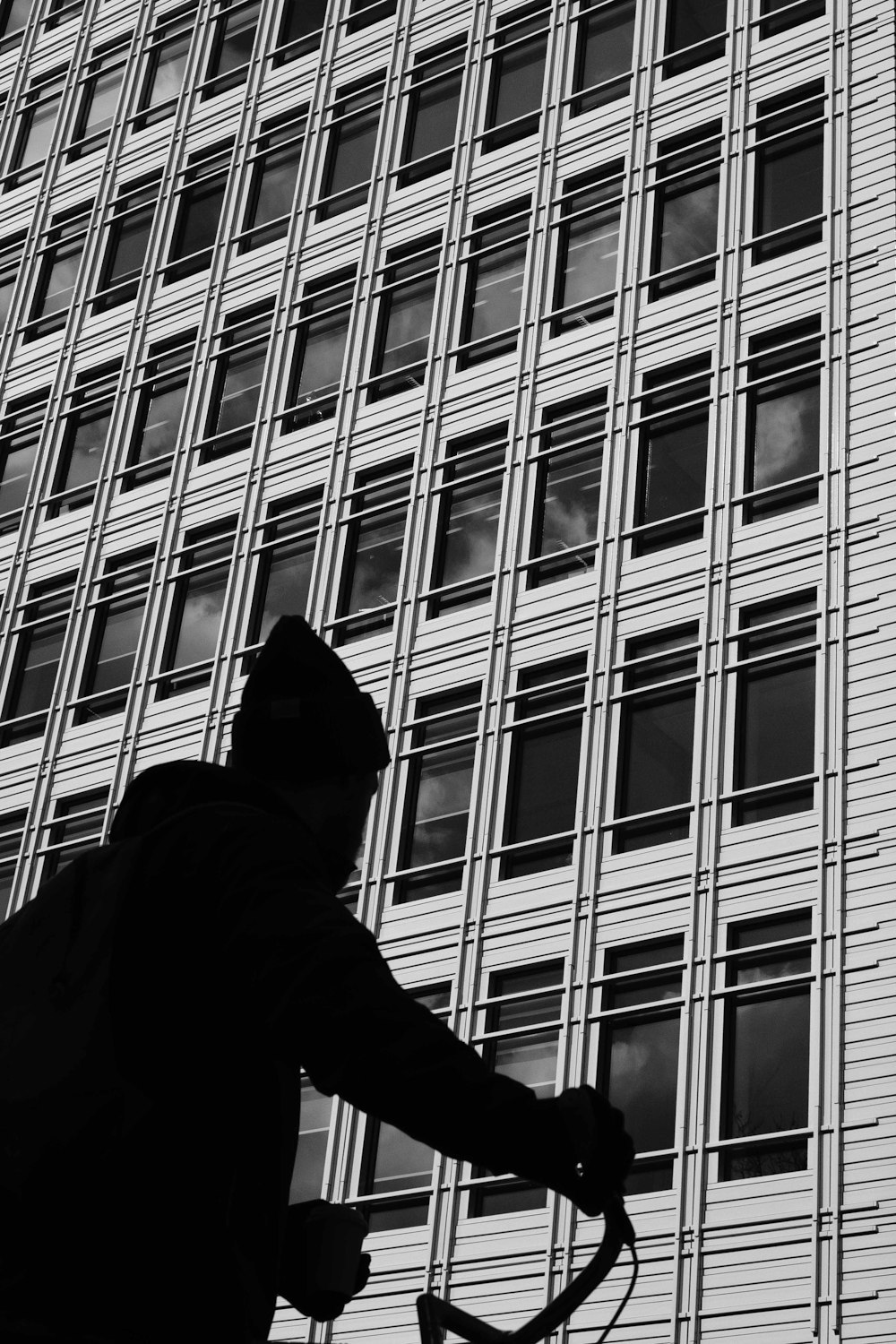 person riding bike in front high rise building