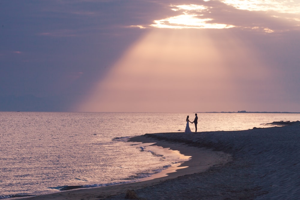 foto silhouette di coppia vicino alla riva del mare