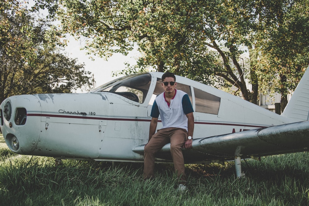 man sitting on biplane wing